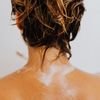 Close-up of wet blonde hair viewed from behind, capturing a moment of showering and wellness.